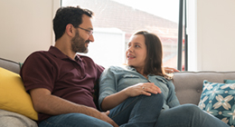 Two people sitting on couch in conversation