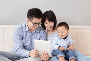 Family of three using First Tech Federal Credit Union Mobile app on a tablet.