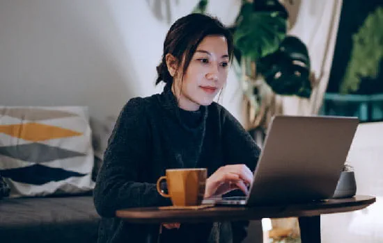 Woman with a cup of coffee using a laptop