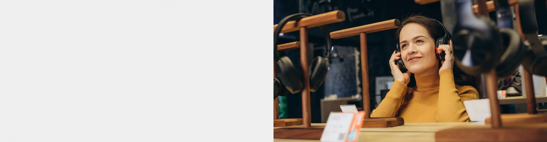 Smiling woman in an orange sweater with over-the-ear headphones