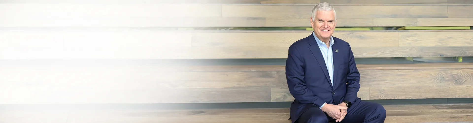 First Tech CEO smiling while sitting on bleachers