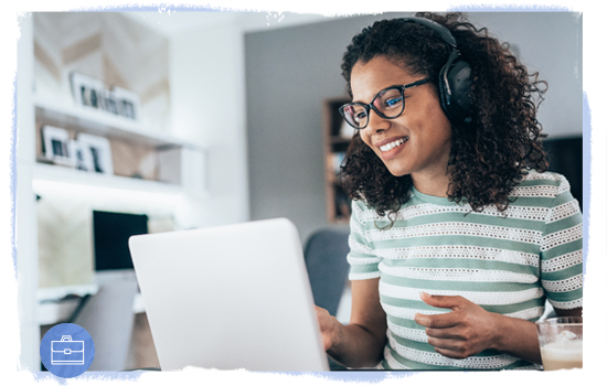 Smiling woman with headphones looking at a laptop computer
