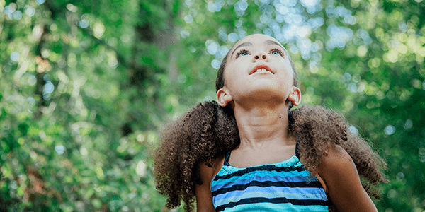Young girl outside looking up