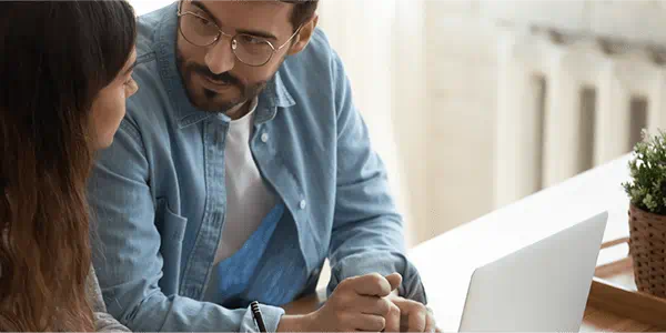 Man and young woman looking at a laptop computer together.