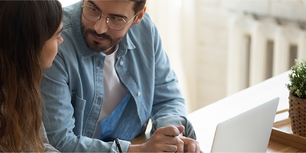 Man and young woman looking at a laptop computer together.