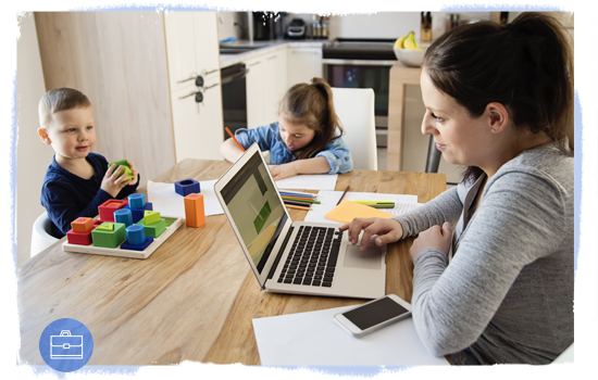 Woman working at kitchen table with children