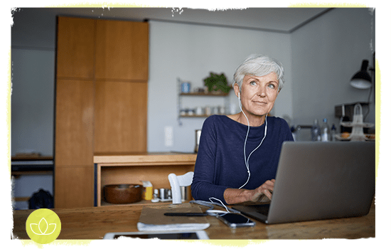 Older lady sitting at laptop looking hopeful