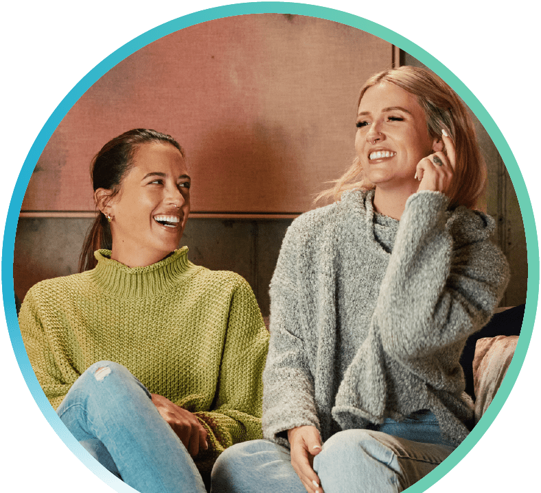 Two people smiling on a couch.