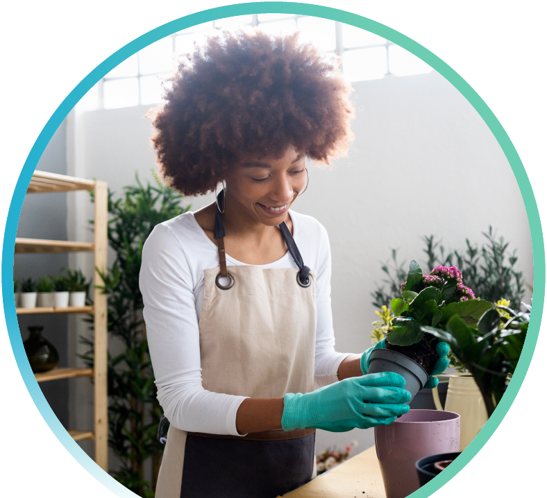 Image of a woman tending to flowers in a pot.