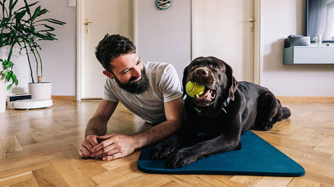 Man and dog on yoga mat
