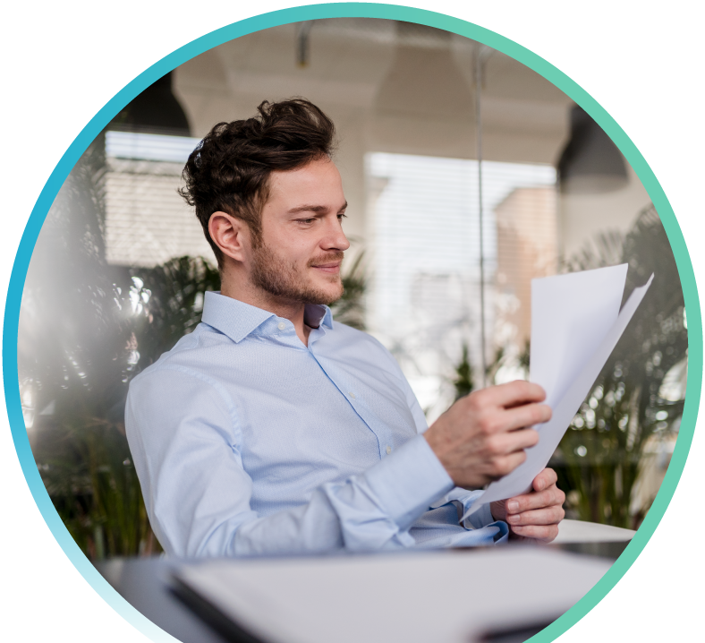 Man with beard in a blue shirt looking at papers