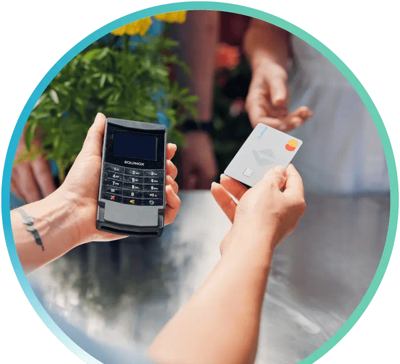A person handing a First Tech Platinum Credit Card in one hand, and an EQUINOX card reader in the other, while motioning to hand the First Tech Platinum Credit Card to another person.