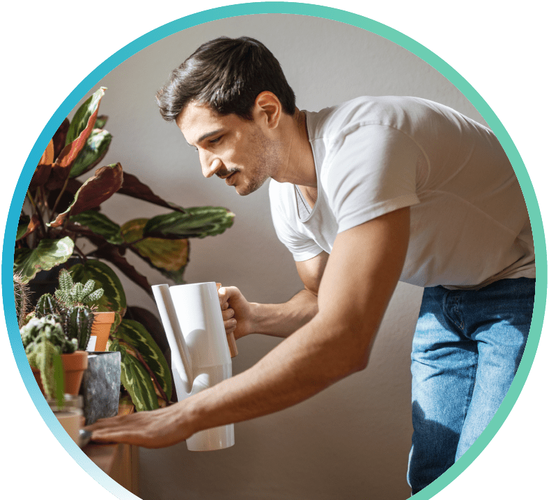 Man watering their indoor plants.