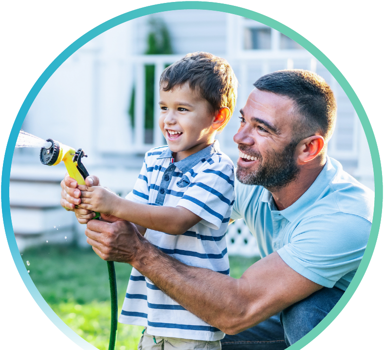 Man and a child holding a water hose