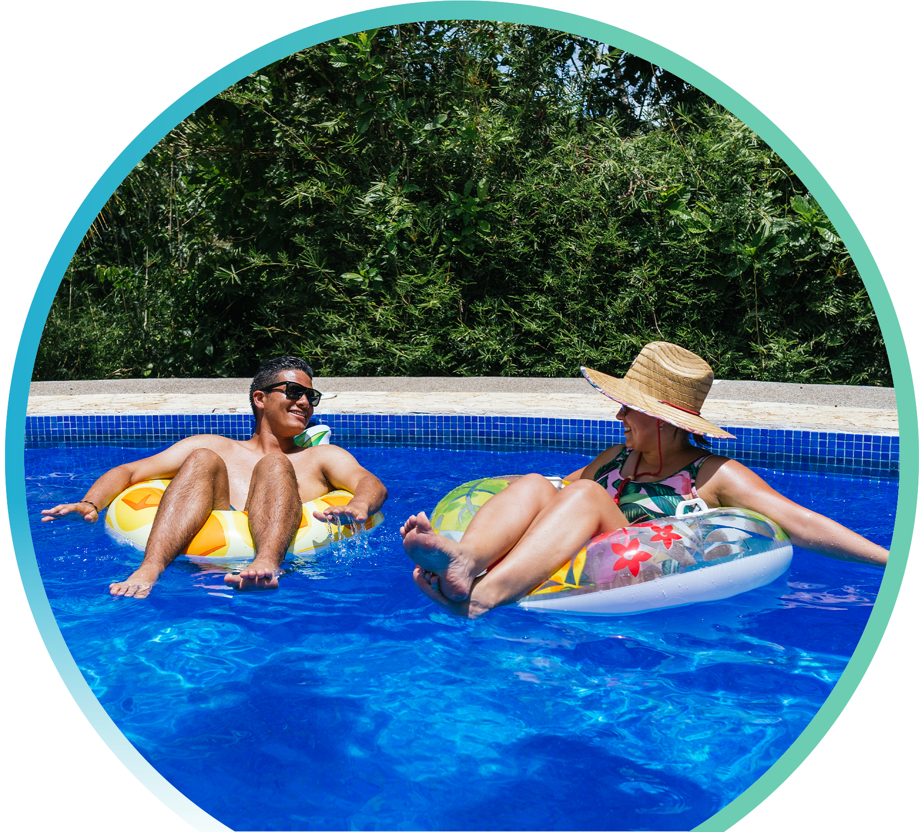 One man and one woman hanging out in a pool on floating tubes