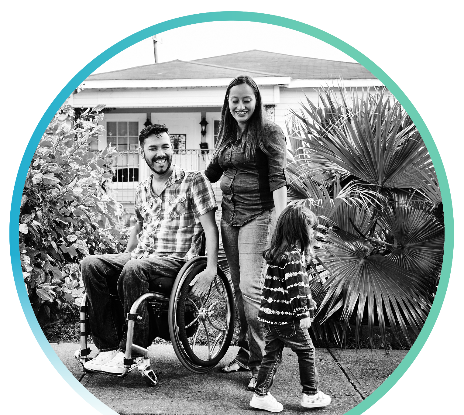 A person in a wheelchair with their partner and child spending time together outside