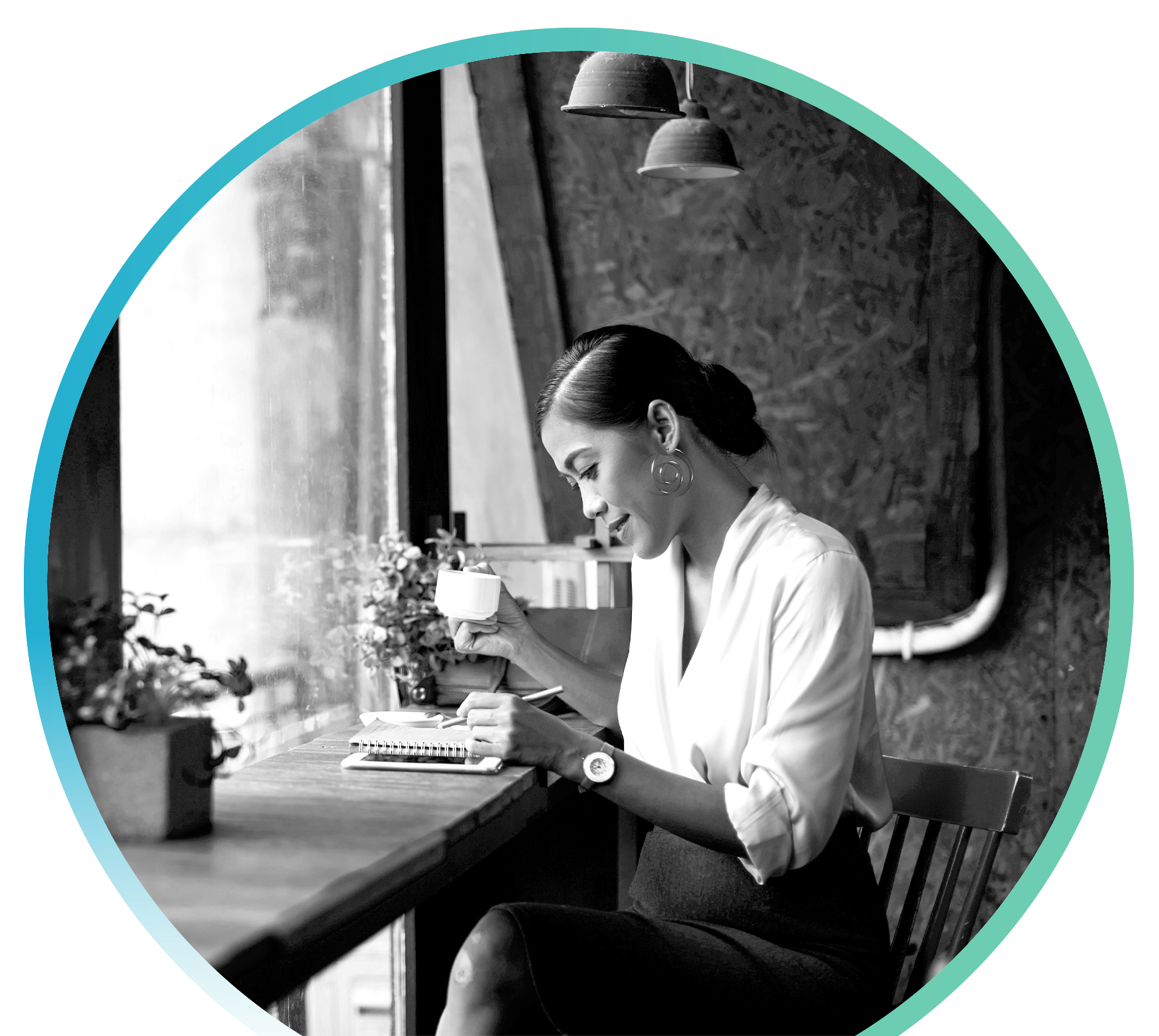 Woman sitting at a desk by a window drinking tea