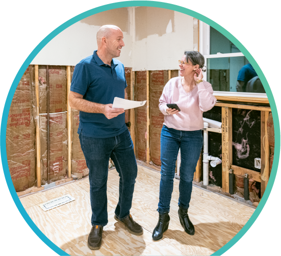Smiling man and woman shown in a room being renovated 