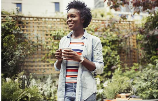 Woman drinking coffee in a garden