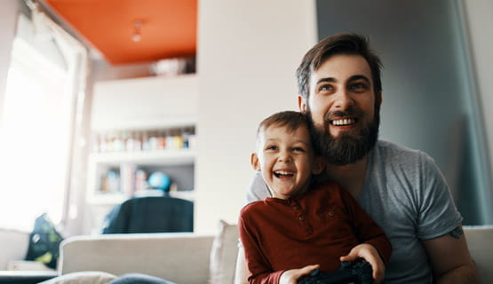 Father and son sitting on the couch playing a video game
