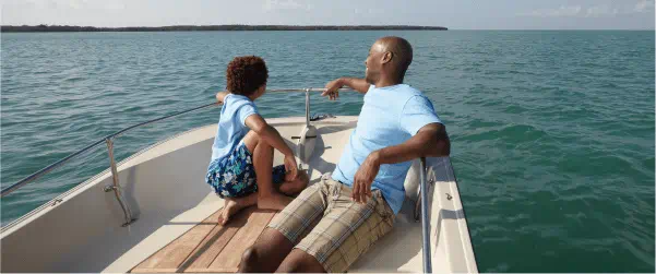 man and child riding in a boat