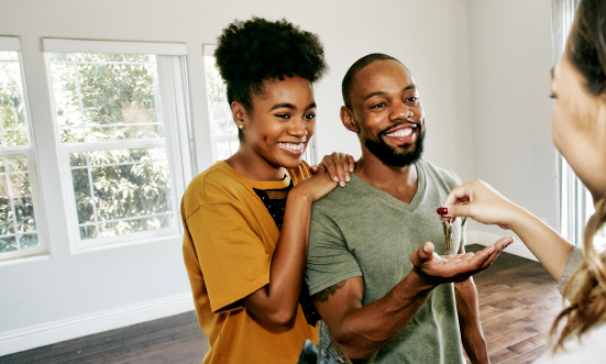 smiling couple being handed keys