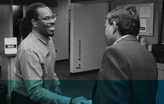 Two men shaking hands in a First Tech experience center branch.