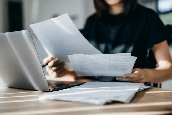 Person looking over tax documents in their hands.
