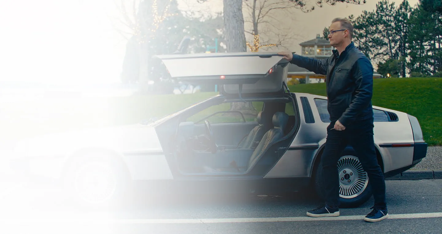 Person next to sports car with a gull wing door.